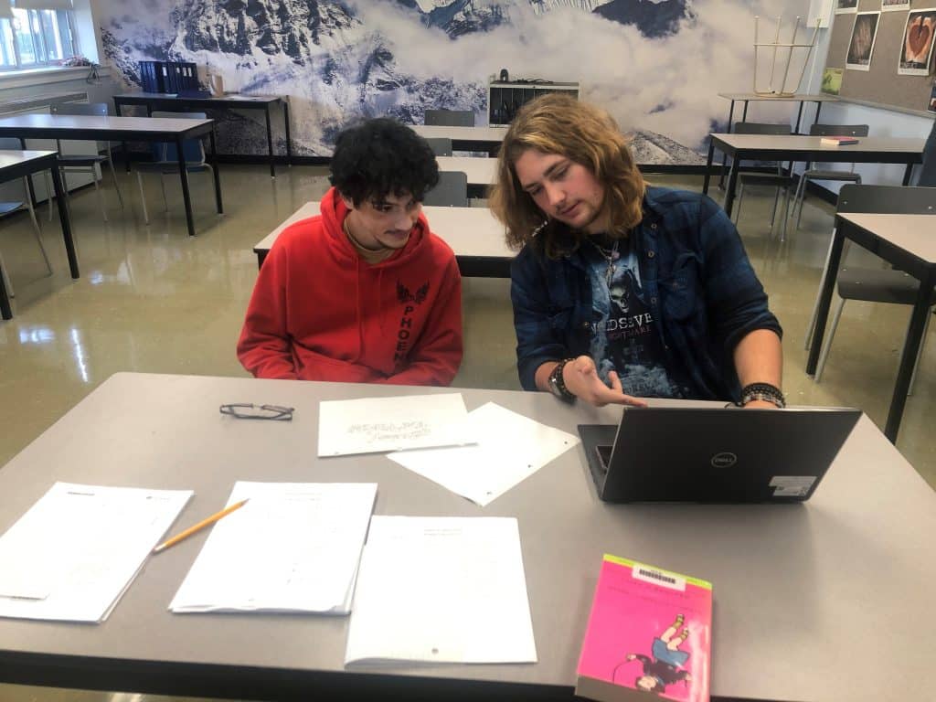 Students talking in a class with a mural of Mt Everest 